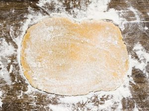 flat-dough-with-white-flour-wooden-surface